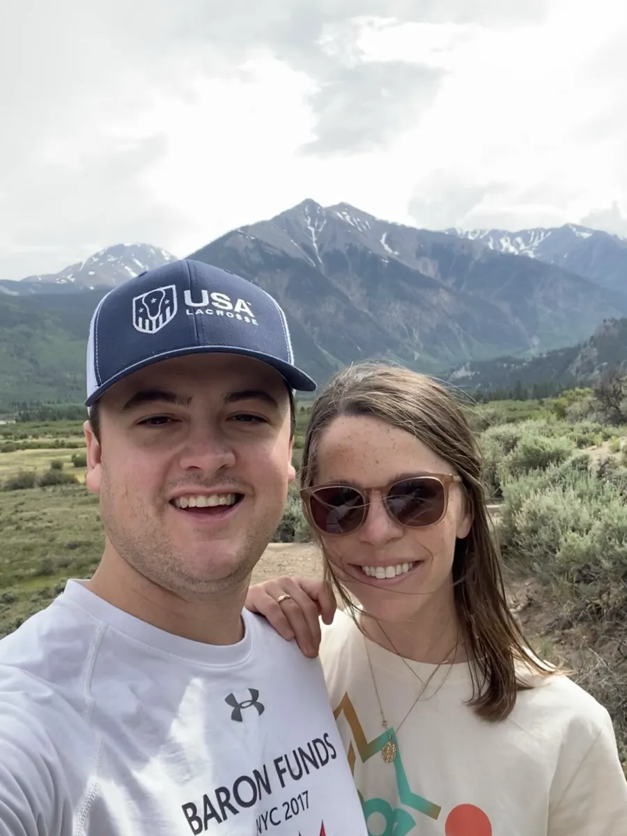 Shelby and Hobey on a trail with snow-capped peaks behind